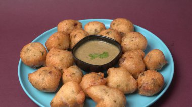 Lezzetli Hint atıştırmalıkları Punugulu yeşil Chutney sosuyla servis edilir. 