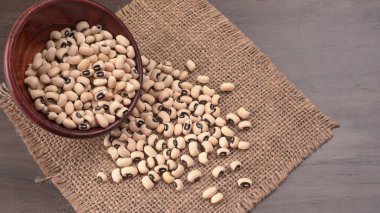 Ahşap kaşıklı pişmemiş siyah bezelyeler. Sağlıklı gıda kavramı.