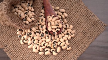 Ahşap kaşıklı pişmemiş siyah bezelyeler. Sağlıklı gıda kavramı.