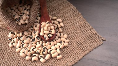 Ahşap kaşıklı pişmemiş siyah bezelyeler. Sağlıklı gıda kavramı.