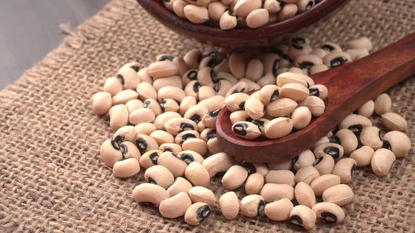 木製のスプーンで調理されていない黒い目のエンドウ豆のボウル 健康食品の概念 — ストック写真