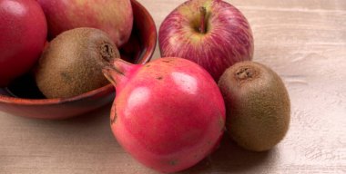 Kivi, elma ve nar arkaplanda fotokopi alanı ile birlikte. Sağlıklı gıda kavramı. Tropik meyveler.