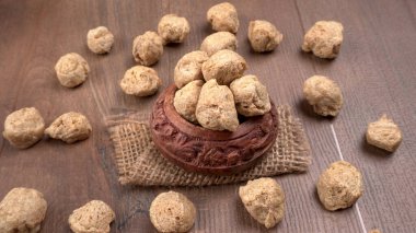 Ahşap arka planda çiğ soya parçaları. Sağlıklı, besleyici soya fasulyesi, kasede parçalar. Vejetaryen gıda konsepti.