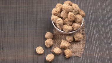 Ahşap arka planda çiğ soya parçaları. Sağlıklı, besleyici soya fasulyesi, kasede parçalar. Vejetaryen gıda konsepti.