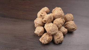 Ahşap arka planda çiğ soya parçaları. Sağlıklı, besleyici soya fasulyesi, kasede parçalar. Vejetaryen gıda konsepti.