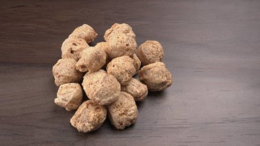 Ahşap arka planda çiğ soya parçaları. Sağlıklı, besleyici soya fasulyesi, kasede parçalar. Vejetaryen gıda konsepti.