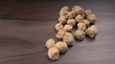 Ahşap arka planda çiğ soya parçaları. Sağlıklı, besleyici soya fasulyesi, kasede parçalar. Vejetaryen gıda konsepti.