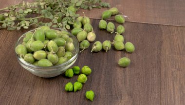 Ahşap zemin üzerinde yeşil bitki örtüsü yığını, yakın çekim.