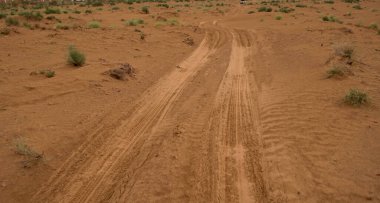 Gündüz vakti araba lastiği izleri olan doğal kum tepecikleri.