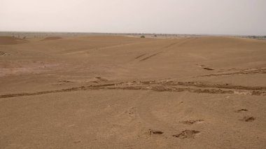 Gündüz vakti araba lastiği izleri olan doğal kum tepecikleri.