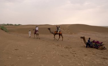 INDIA - 08 AĞUSTOS 2019: Gündüz vakti Hindistan çölünde deveye binen turistler 