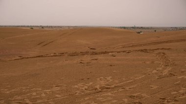Gündüz vakti araba lastiği izleri olan doğal kum tepecikleri.