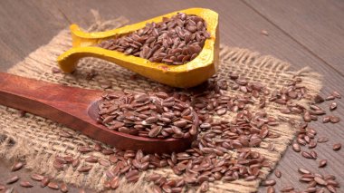 Kaşık ve kase dolusu kahverengi keten tohumu ya da ahşap arka planda keten tohumu. Diyet sağlık hizmeti sağlıklı gıdalar.