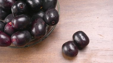 Tahta arka planda siyah hurmalar kasesi 