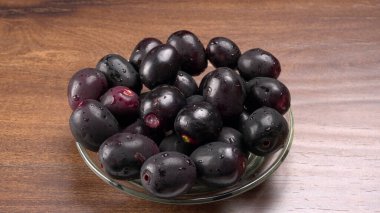 Tahta arka planda siyah hurmalar kasesi 