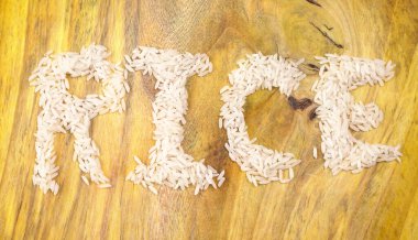 Tahta masada çiğ pirinç yığını, sağlıklı yiyecekler. Boşluğu kopyala.