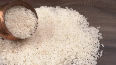 Tahta masanın üzerinde metal bir kase kuru pirinç. Sağlıklı yemek. 