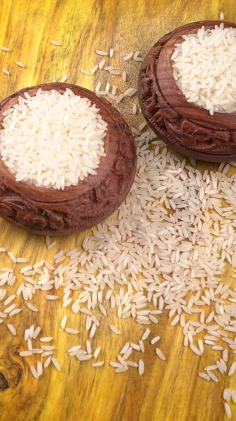 未煮熟的干米饭放在木制桌子上的粘土褐色碗里 健康食品 复制空间 — 图库照片