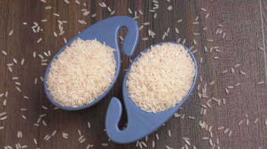 Tahta masada, plastik mavi kaselerde çiğ pirinç, sağlıklı yiyecekler. Boşluğu kopyala.