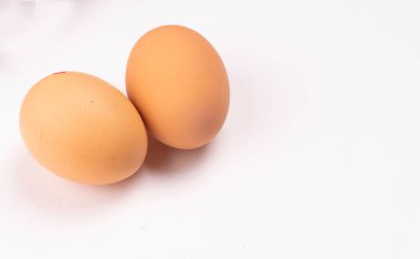 beyaz zemin üzerine iki çiğ yumurta