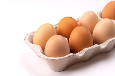 Beyaz arka planda taze tavuk yumurtaları olan karton kutu, yakın plan. 