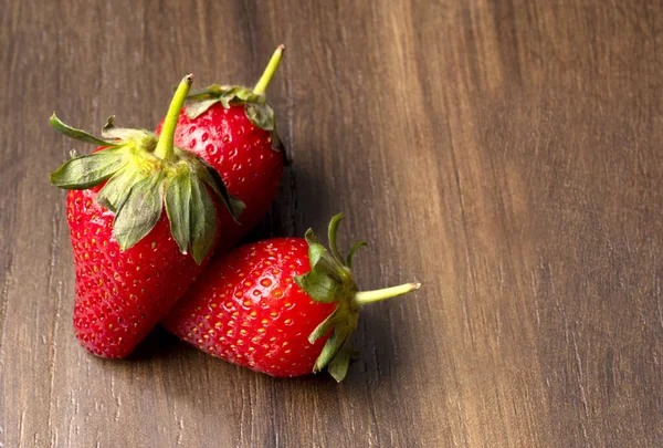 Tres Jugosas Fresas Una Mesa Rústica Marrón — Foto de Stock