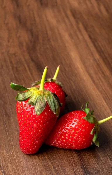 Tres Jugosas Fresas Una Mesa Rústica Marrón — Foto de Stock