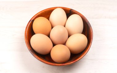 Tahta kase çiğ tavuk yumurtası hafif ahşap arka plan, yakın çekim. 