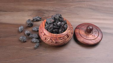 Tahta kase kurumuş siyah hurma ve ahşap kapak, yakın plan. 