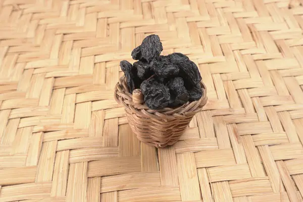 Nahaufnahme Von Weidenkorb Mit Getrockneten Schwarzen Datteln Auf Holztisch — Stockfoto