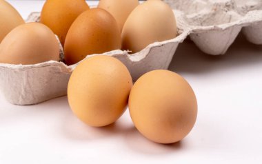 Karton yumurta tepsisinde kahverengi tavuk yumurtası. Sağlıklı protein kahvaltısı için organik yumurta. Paskalya sembolü. Çiğ tavuk yumurtası..