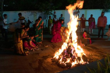 INDIA - 17. Mart 2022: Hindu dindarlar, Holi 'nin bahar bayramı arifesinde Holika Dahan sırasında şenlik ateşi etrafında kutsal ayinler düzenlerler.