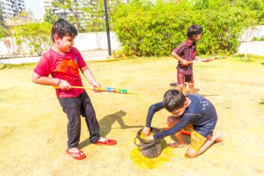 INDIA - 18 Mart 2022: Çocuklar gündüz vakti bahçede su tabancalarıyla oynuyorlar 