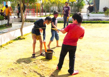 INDIA - 18 Mart 2022: Çocuklar gündüz vakti bahçede su tabancalarıyla oynuyorlar 