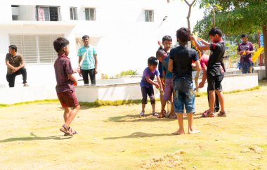 INDIA - 18 Mart 2022: Çocuklar gündüz vakti bahçede su tabancalarıyla oynuyorlar 