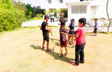 INDIA - 18 Mart 2022: Çocuklar gündüz vakti bahçede su tabancalarıyla oynuyorlar 