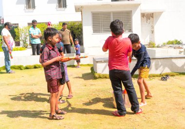 INDIA - 18 Mart 2022: Çocuklar gündüz vakti bahçede su tabancalarıyla oynuyorlar 