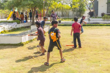 INDIA - 18 Mart 2022: Çocuklar gündüz vakti bahçede su tabancalarıyla oynuyorlar 