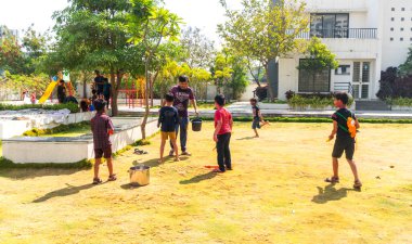 INDIA - 18 Mart 2022: Çocuklar gündüz vakti bahçede su tabancalarıyla oynuyorlar 