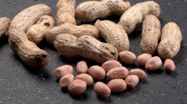 Siyah arka planda kabuklu organik fıstıklara yakın çekim. Sağlıklı ve besleyici gıdalar için birebir..