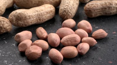 Siyah arka planda kabuklu organik fıstıklara yakın çekim. Sağlıklı ve besleyici gıdalar için birebir..