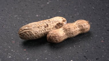 Siyah arka planda kabuklu organik fıstıklara yakın çekim. Sağlıklı ve besleyici gıdalar için birebir..