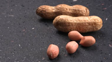 Siyah arka planda kabuklu organik fıstıklara yakın çekim. Sağlıklı ve besleyici gıdalar için birebir..