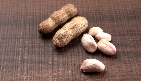 木製の背景に貝の有機ピーナッツの山 健康的で栄養価の高い — ストック写真