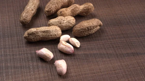 木製の背景に貝の有機ピーナッツの山 健康的で栄養価の高い — ストック写真