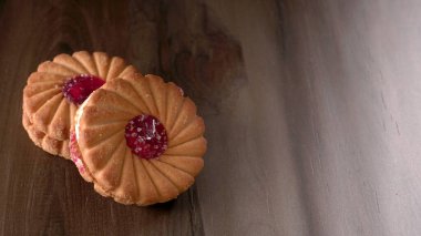 Tatlı reçelli bisküvilerin en üst görüntüsü. Sandviç bisküvileri veya ahşap arka planda kremalı bisküviler. 