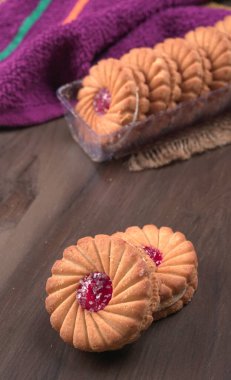 Tatlı reçelli bisküvilerin en üst görüntüsü. Sandviç bisküvileri veya ahşap arka planda kremalı bisküviler. 