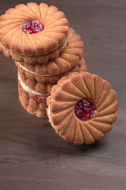 Tatlı reçelli bisküvilerin en üst görüntüsü. Sandviç bisküvileri veya ahşap arka planda kremalı bisküviler. 