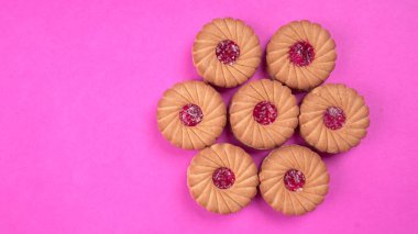 Tatlı reçelli bisküvi yığını. Sandviç bisküvileri ya da pembe arka planda kremalı bisküviler. 