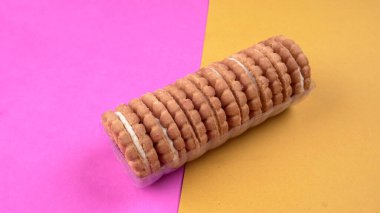 Tatlı reçelli bisküvi yığını. Sandviç bisküvileri veya pembe-sarı arka planda kremalı bisküviler. 